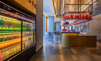 The restaurant has an open concept design with tables and chairs, allowing for easy storage of items along the wall at MUYI Hotel Hongqiao Hub Shanghai