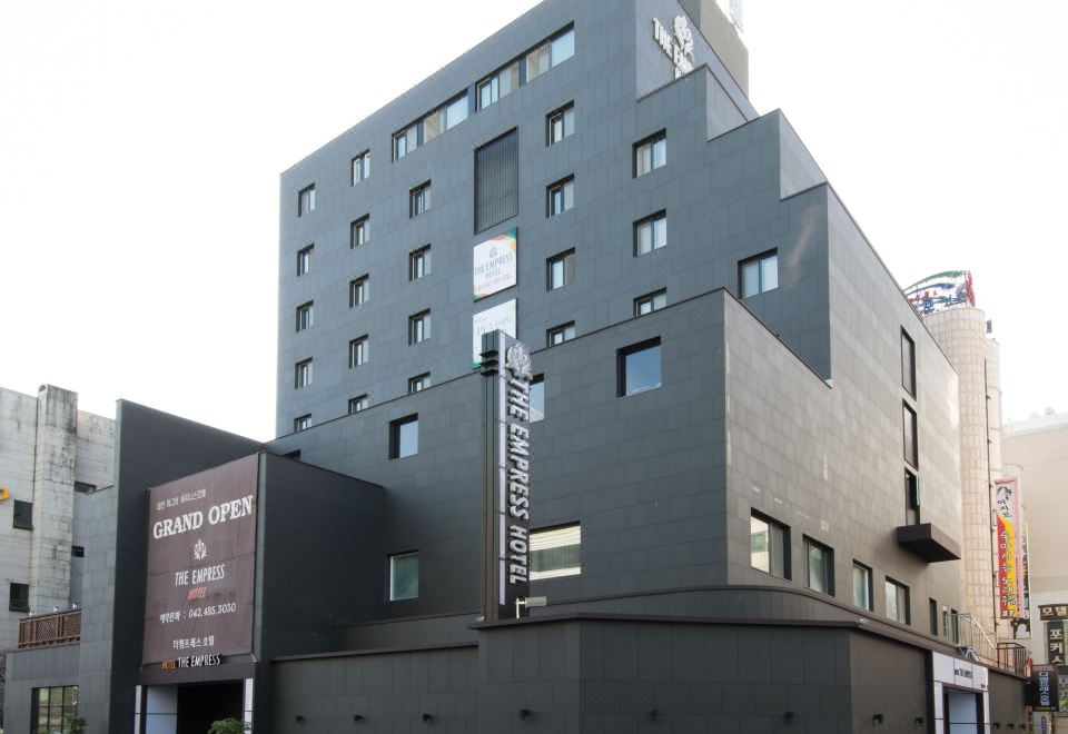 a modern building with a black exterior and large windows is situated on a street corner at The Empress Hotel