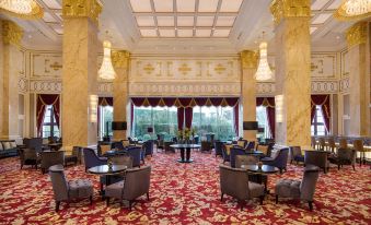 There is a spacious room with tables and chairs in the center, accompanied by an elaborate ceiling at Radisson Blu Forest Manor Shanghai Hongqiao
