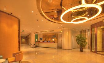 The large room is illuminated by lights on the ceiling, and there is an illuminated reception area in front at Holiday Inn Express Shanghai Zhenping