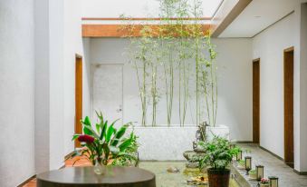 a modern , minimalist interior with a glass partition and wooden table , surrounded by plants and flowers at Gengting Hotel