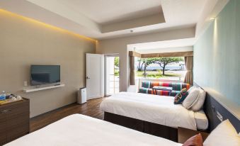 a modern hotel room with two beds , a tv , and a view of the outdoors at Sunset Beach Hotel