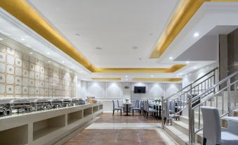 The restaurant features an open concept floor plan with tables and chairs in the center at Vienna Hotel (Guangzhou railway station & Xiaobei subway station)