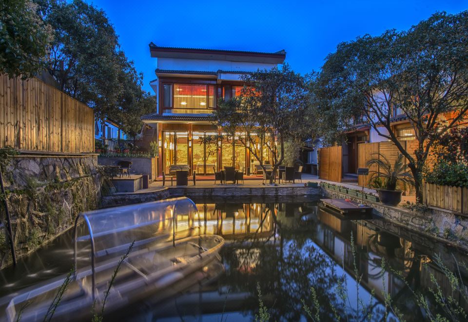 The nighttime exterior view showcases a spacious pool and an outdoor seating area at West Lake Teavilla