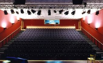 a large auditorium with rows of chairs arranged in a semicircle , and a stage set up for an event at Crowne Plaza Dublin - Blanchardstown