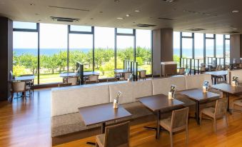 a modern restaurant with wooden floors , large windows offering views of the outdoors , and comfortable seating areas at Rex Hotel Beppu