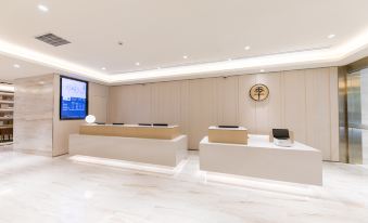 The room is white with ample lighting on the walls, and there is an office reception desk beside it at Ji Hotel (Shanghai Hongqiao Shuicheng Road)