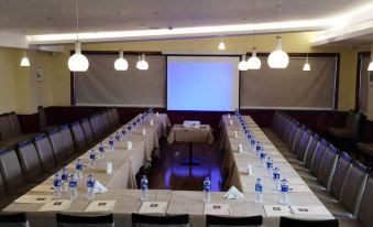 A spacious room is arranged with long tables and chairs for events or functions at Merchant Marco Edgelake Hotel