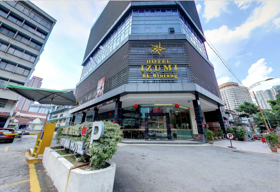 There is a large building with a visible name on its side located in front of an outdoor view at Izumi Hotel Bukit Bintang Kuala Lumpur