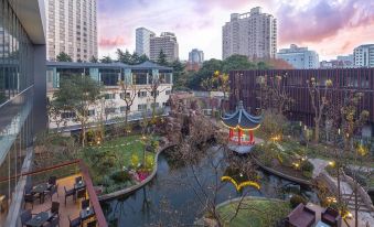 There is a small pond in the middle, surrounded by buildings and restaurants on both sides, creating an oriental atmosphere at Golden Tulip Shanghai