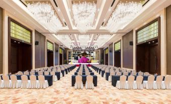 a large , well - lit conference room with multiple rows of chairs and tables set up for an event at Kusatsu Hotel