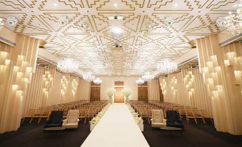 a large , elegant room with high ceilings and a long aisle leading to an elegant wedding chapel at The Riverside Hotel