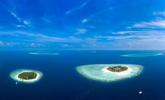 a panoramic view of the maldives , showcasing two small islands surrounded by deep blue water at Banyan Tree Vabbinfaru