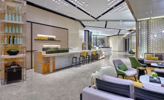 has a seating area in the center and an open kitchen adjacent to it at Hampton by Hilton Shenzhen North Station
