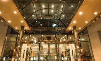 At night, there is a large building with glass panels on both sides, featuring a lobby and entrance at Park Inn by Radisson Shanghai Downtown
