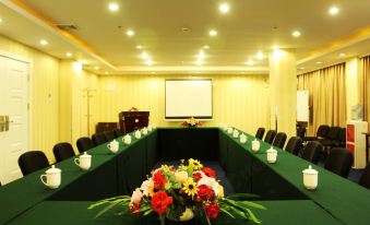 A spacious conference room is arranged with green chairs and long tables for events or meetings at Ruizhao Hotel (Beijing Guomao)