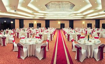 A ballroom is arranged for an event, with tables and chairs placed in the center at Parsian Azadi Hotel