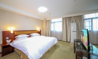 The bedroom features a large bed and a table by the window, complemented by white curtains on each side at City Comfort Inn (Xiangyang Railway Station)