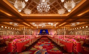A ballroom is arranged for a wedding, featuring tables and chairs, as well as chandeliers hanging from the ceiling at Wynn Palace