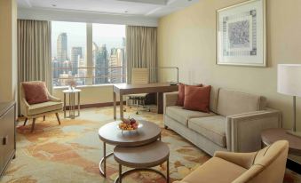 The living room features large windows and furniture, including couches positioned in front of them at Radisson Blu Hotel Shanghai New World