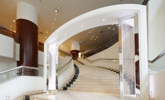 The large building features a lobby and staircase with glass panels on both sides at B P International