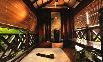 a serene indoor space with wooden walls , bamboo ceiling , and a large window that reflects the beauty of nature at Paya Beach Spa & Dive Resort