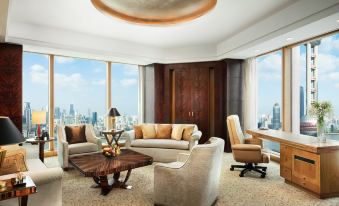 The living room features large windows, furniture in the middle, and an adjacent open space at Pudong Shangri-La, Shanghai