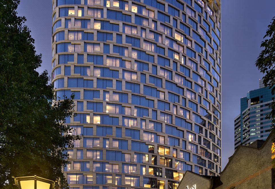 At night, there is a large building with windows and balconies on the side at The Langham Shanghai Xintiandi