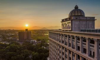 "a large hotel building with the name "" vallarta "" on it , set against a beautiful sunset in a city" at Hotel Valletta