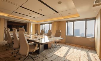 The office or conference has a meeting room featuring large windows and modern chairs surrounding the table at Radisson Collection Hotel, Yangtze Shanghai