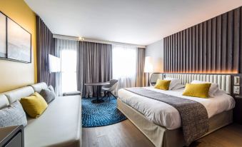 a modern hotel room with a large bed , couch , and dining table , all situated in a well - lit space at Best Western Premier Hotel de la Paix