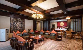 a luxurious living room with wooden furniture , including a couch , chairs , and a dining table at Paradise Hotel