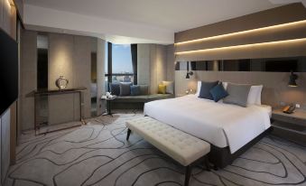The middle room features a spacious bed, an attached sitting area, and a window on one side at The Harbourview-Chinese YMCA of Hong Kong