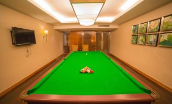 The middle room features a game table with an arcade machine and a pool table on top for entertainment purposes at New Joyful Hotel