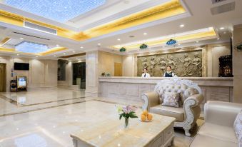 The lobby of this luxury hotel is clean and modern, featuring a large marble reception desk at Vienna Hotel (Guangzhou railway station & Xiaobei subway station)