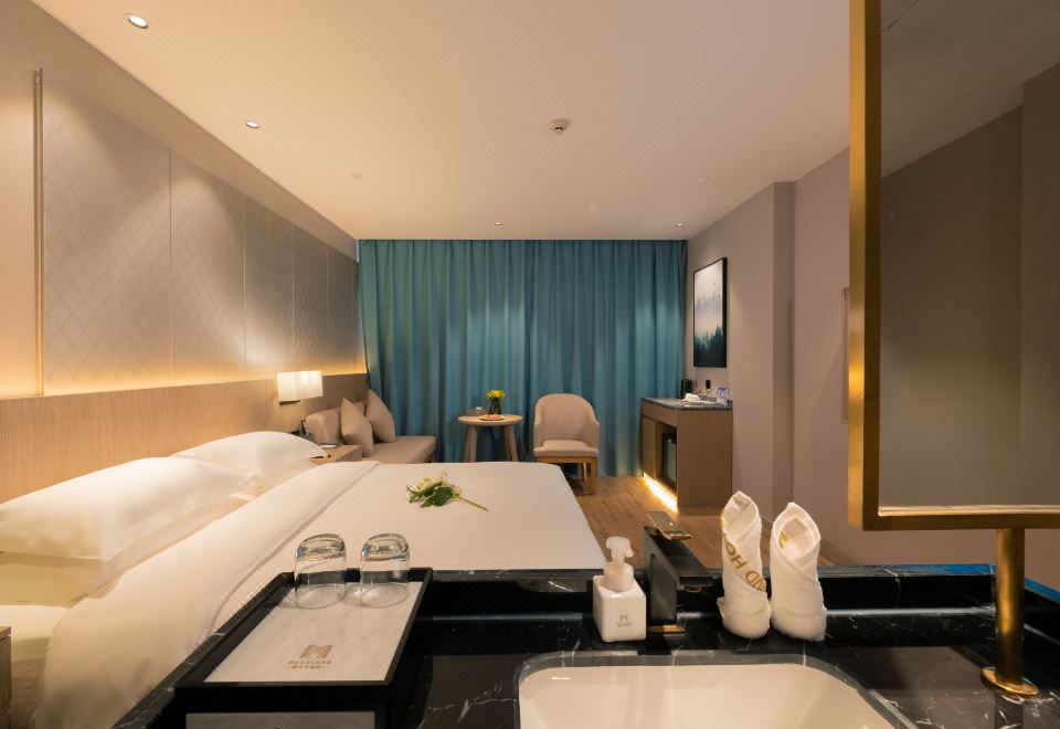 The spacious living area features a double bed, as well as a table and chairs at Yiwu Mankalan Hotel (International Trade City Xinguanghui Branch)