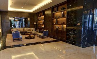 a luxurious hotel lobby with marble floors , wooden furniture , and a large painting on the wall at Somerset Grand Central Dalian