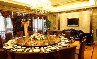 a formal dining room with a large round table surrounded by chairs , all set for a meal at Relax Hotel