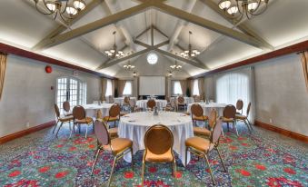 a large room with multiple round tables and chairs , all set up for a formal event at St. Eugene Golf Resort & Casino