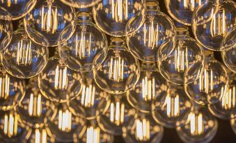 a close - up view of a group of light bulbs hanging from the ceiling , illuminating the room at Sage Melbourne Ringwood