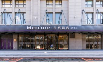 "the entrance to a mercure hotel with the name "" mercure "" written on it , and a person standing in front of it" at Hengxing Mercure Hotel