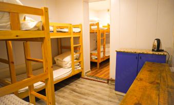 There is a bedroom with bunk beds and two wooden bedspreads in a dormitory style at Paoju Factory Youth Hostel (Beijing Summer Palace Subway Station Branch)