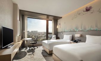 The modern bedroom features double beds, large windows, and a city view at Hilton Garden Inn Shanghai Hongqiao NECC