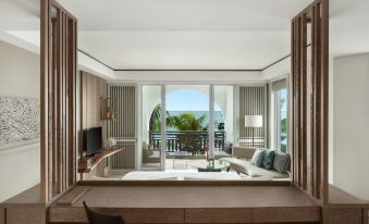 a modern living room with large windows offering a view of the ocean , featuring wooden furniture and comfortable seating arrangements at Shangri-La le Touessrok, Mauritius