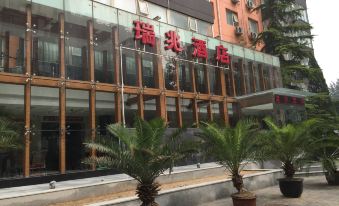 The entrance of a hotel is visible, with buildings on both sides and an outside view at Ruizhao Hotel (Beijing Guomao)