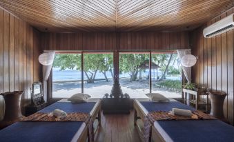 a room with two beds , one on the left and one on the right , both covered with blue blankets at Gangga Island Resort & Spa
