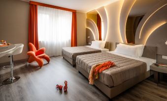 a modern bedroom with two beds , a chair , and a small dog toy on the floor at Hotel Da Vinci
