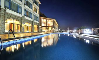 The hotel building is surrounded by other hotels and has a large swimming pool at Beidaihe Bei Hua Yuan Sea View Hotel (Beidaihe Biluo Tower)