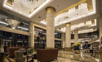 a luxurious hotel lobby with a large chandelier hanging from the ceiling , surrounded by marble floors and elegant furniture at The One Hotel