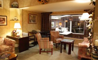 a living room with two chairs , a coffee table , and a large window overlooking a patio at Auberge Gisele's Inn
